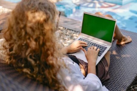 Woman with computer at poolside working from the patio livingonthepatio.com